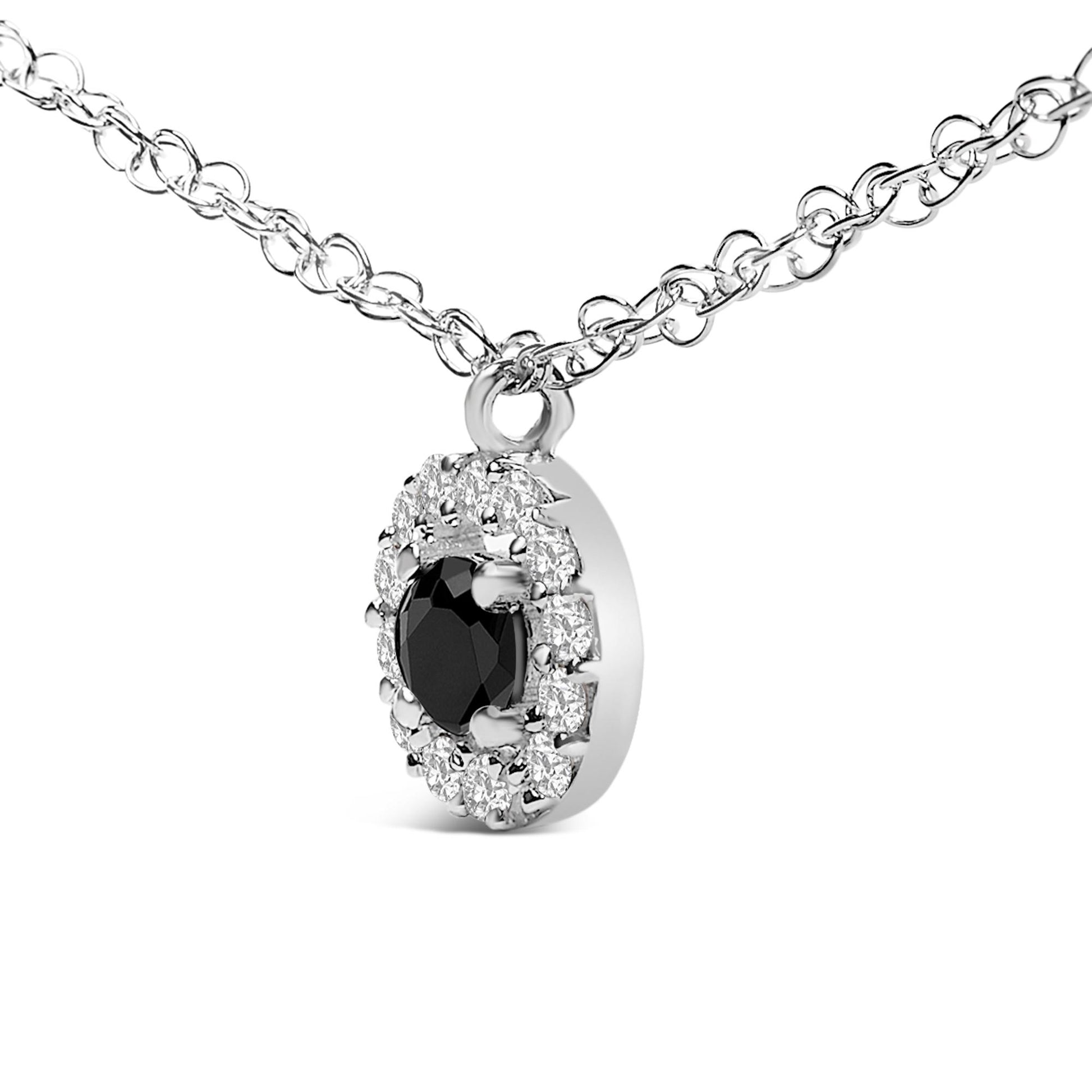 Close-up front angle of a white metal necklace chain with an oval-shaped pendant featuring a central black gemstone surrounded by smaller white gemstones in prong settings.