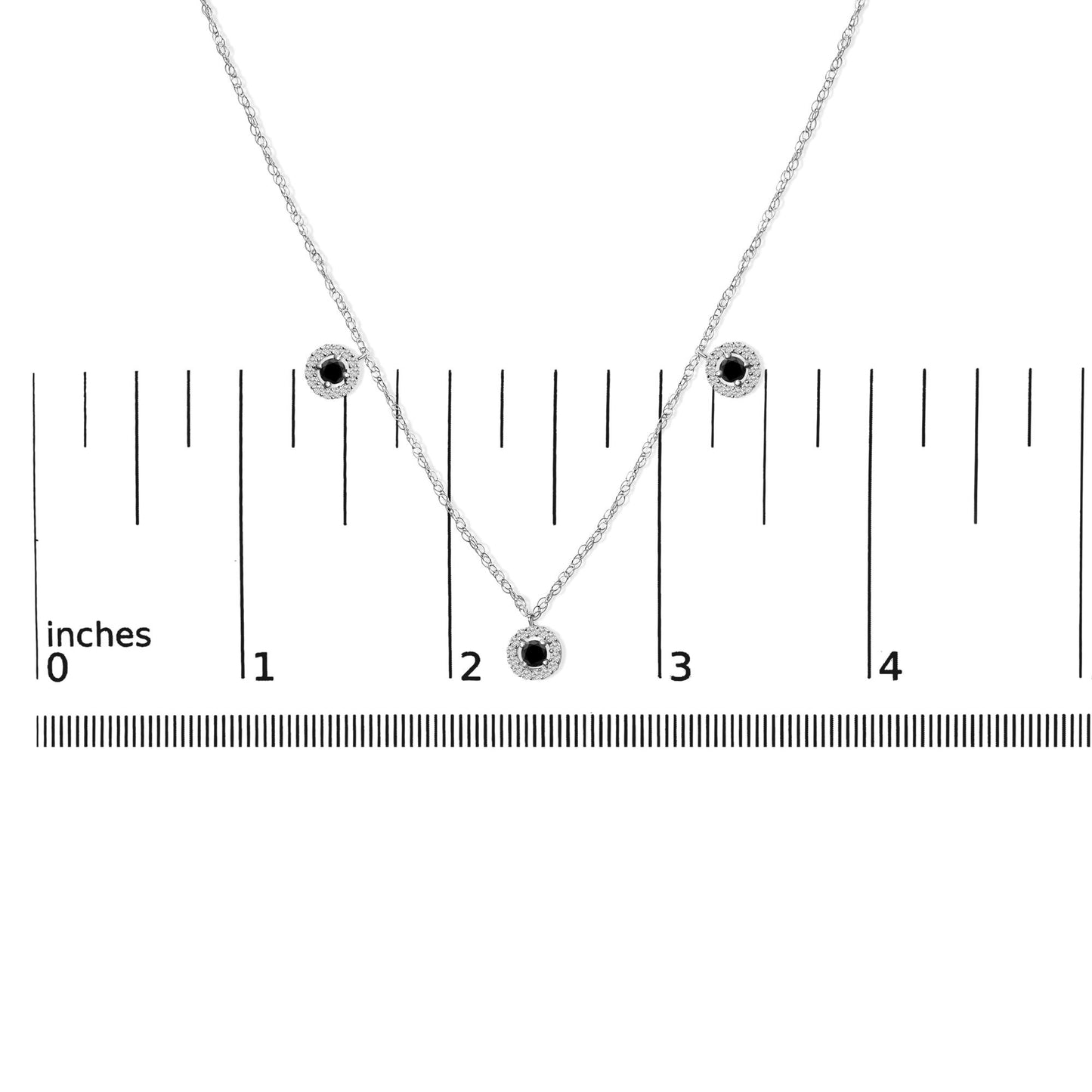 White metal necklace with a pendant featuring a round black gemstone surrounded by white gemstones, shown on a scale from a front angle.