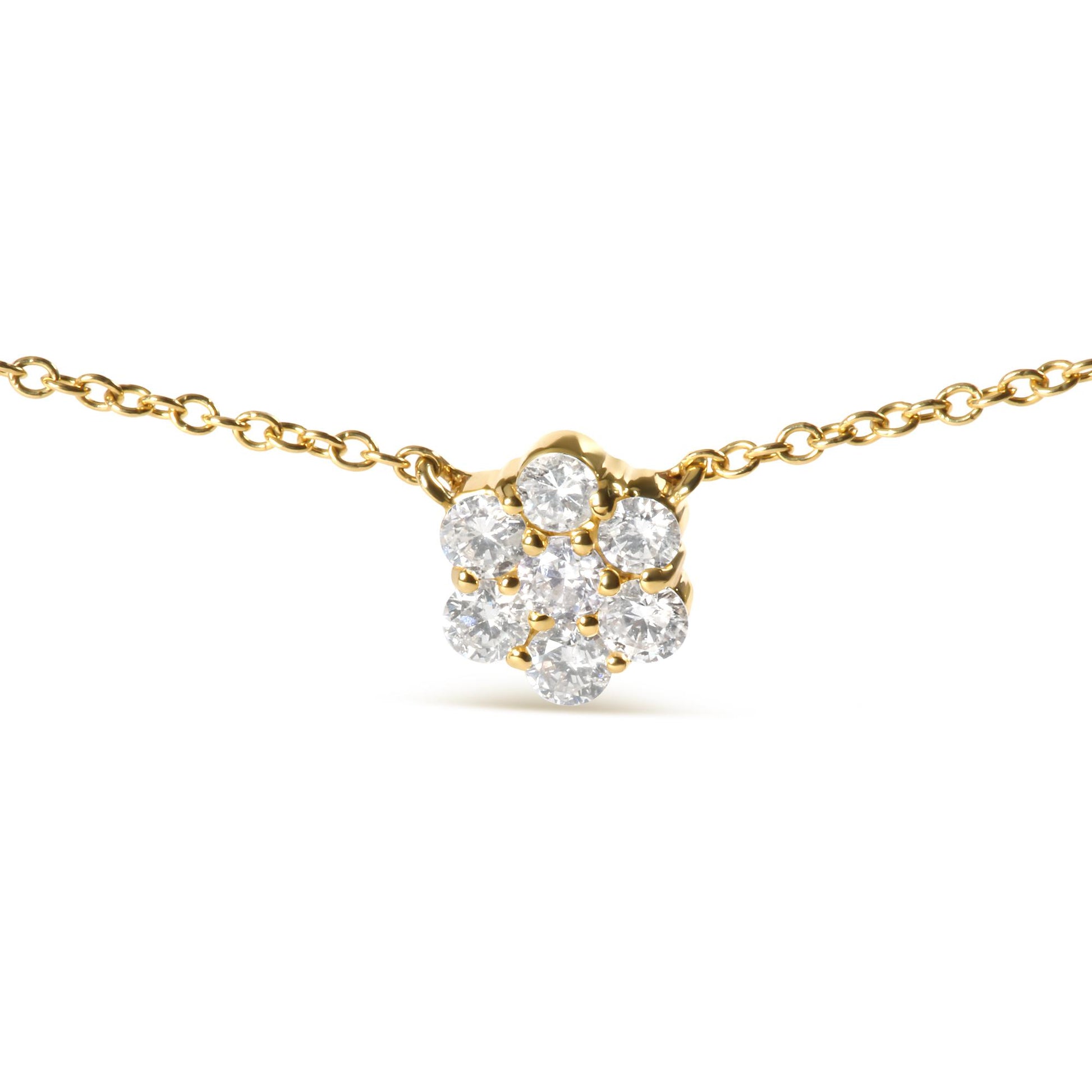 Close-up front view of a yellow metal necklace with a flower-shaped cluster of round white gemstones in prong settings.