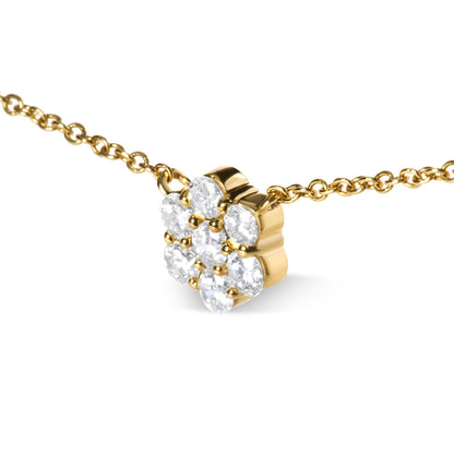 Close-up angle of a yellow metal necklace with a pendant featuring round white gemstones in a prong setting arranged in a cluster.