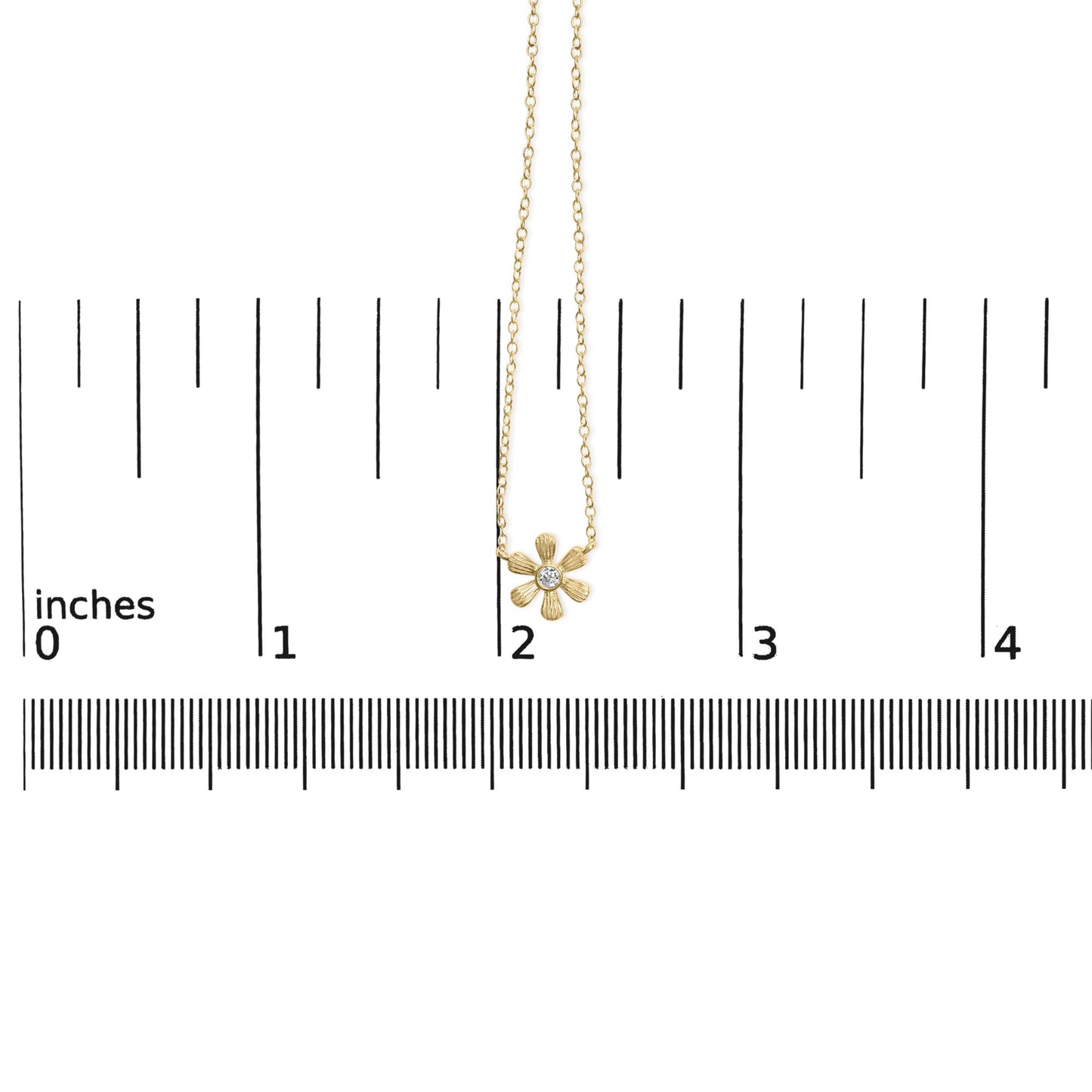 Yellow metal necklace with a flower-shaped pendant featuring a round white gemstone in the center, shown hanging on a ruler for size reference, front view.