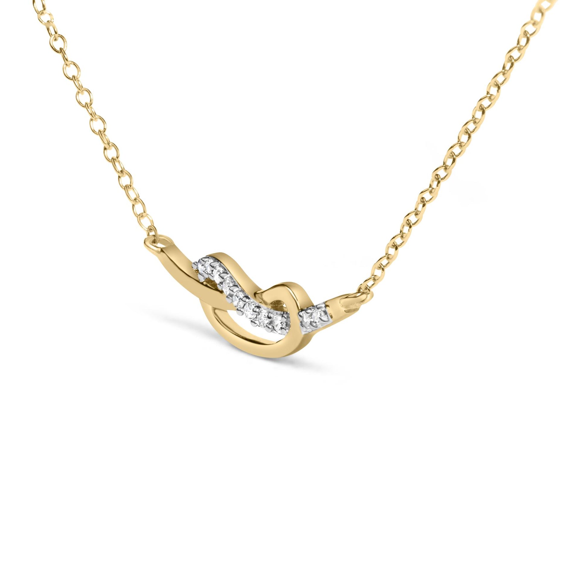 Yellow metal necklace with a twist design accentuated by small white gemstones, shown in a close-up angled view.