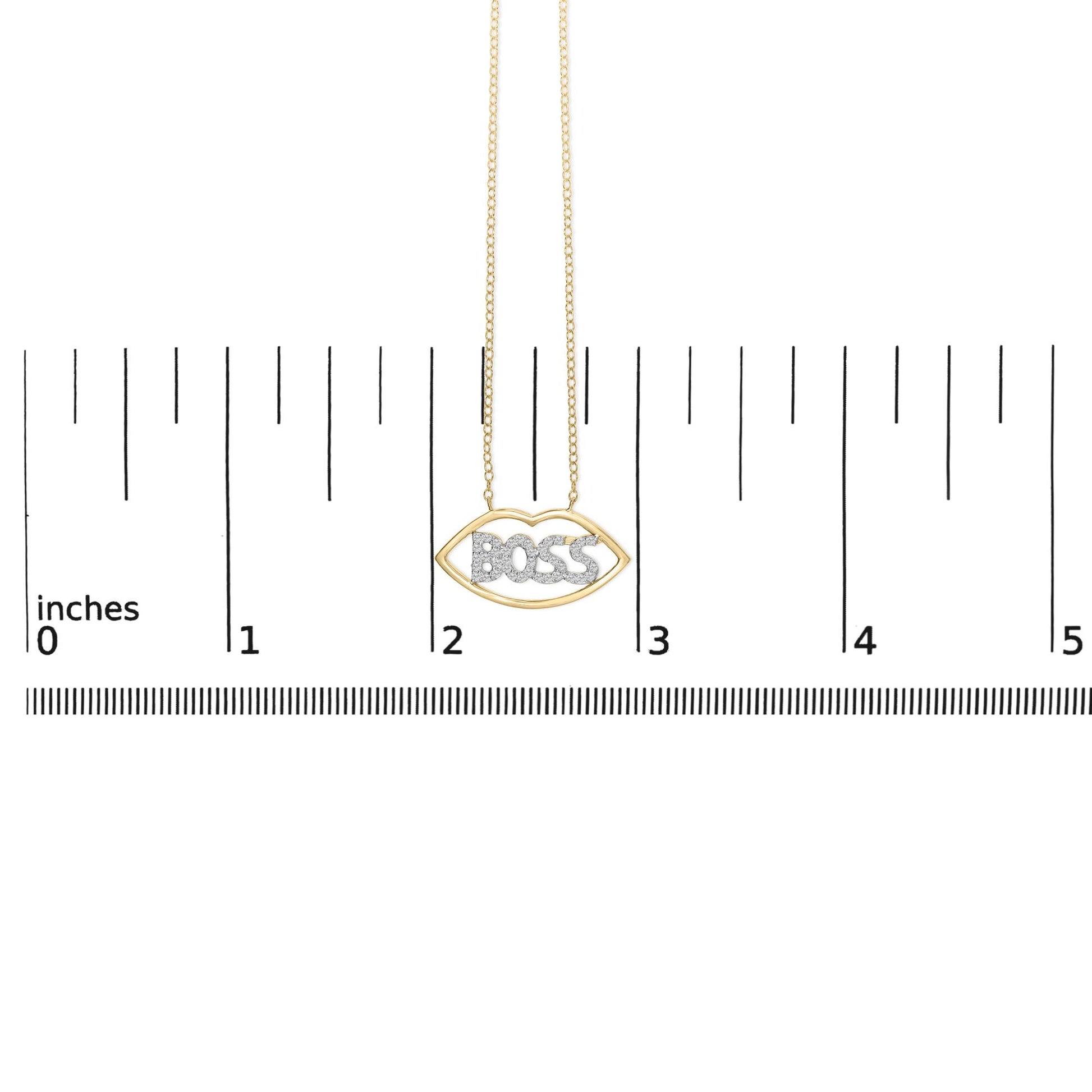 Yellow and white metal necklace with a lip-shaped pendant featuring the word 'BOSS' set with round white gemstones, shown hanging against a ruler scale, front view.