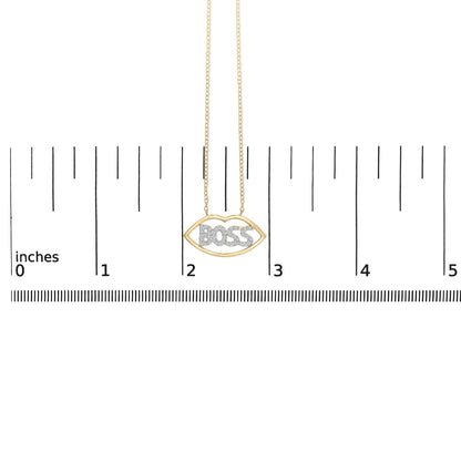 Yellow and white metal necklace with a lip-shaped pendant featuring the word 'BOSS' set with round white gemstones, shown hanging against a ruler scale, front view.