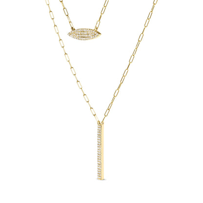 Close-up angled view of a yellow metal necklace with two pendants featuring prong-set white round gemstones, one in an elongated oval shape and the other in a vertical bar shape.