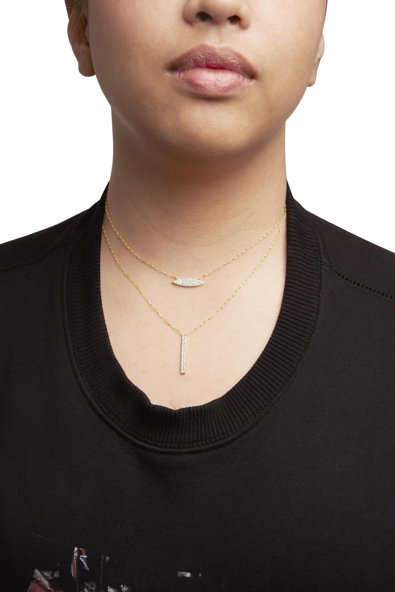 Front view of a model wearing two layered yellow necklaces featuring white round gemstones in prong settings, one with a horizontal marquise-shaped pendant and the other with a vertical bar pendant.