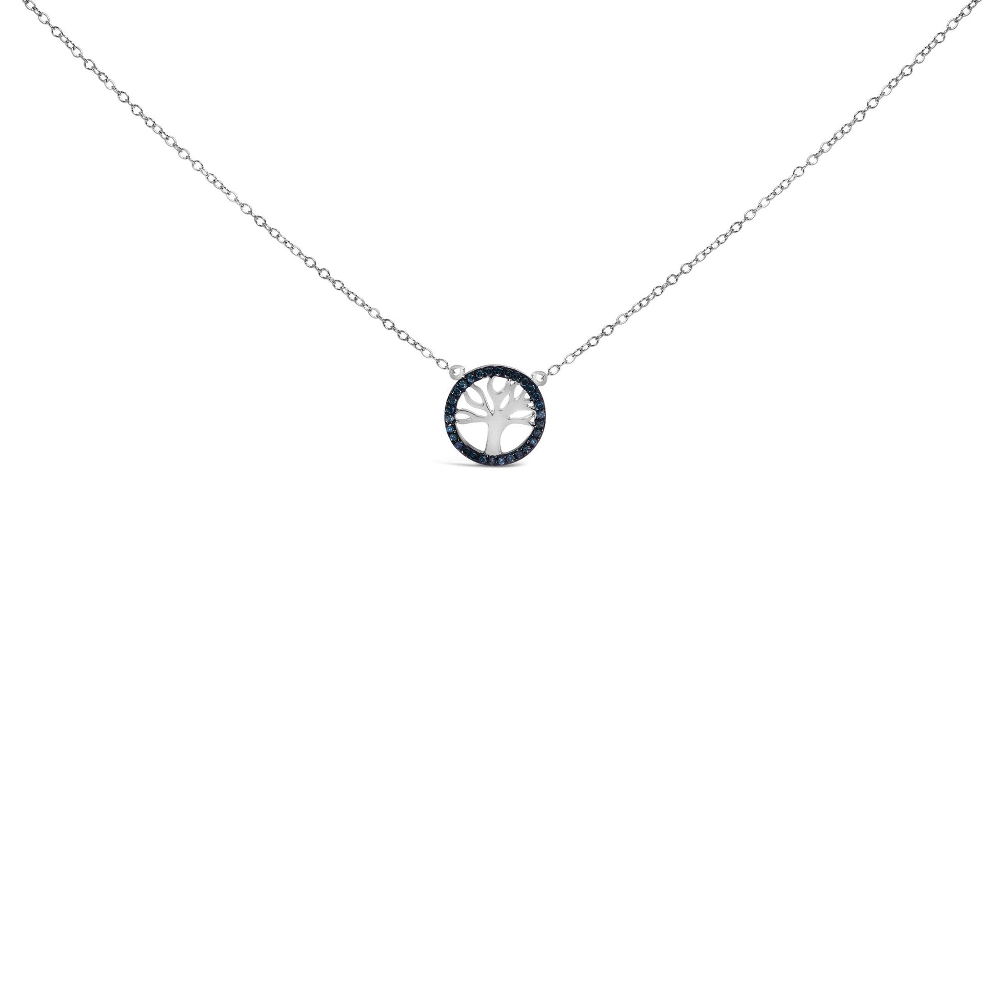 Front-facing shot of a white metal necklace featuring a circular pendant with a tree cutout, surrounded by round blue gemstones in prong settings.