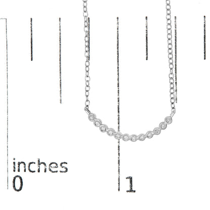 White metal necklace with a curved bar featuring a row of round white gemstones in prong settings, shown on a scale with inch markings, front view.