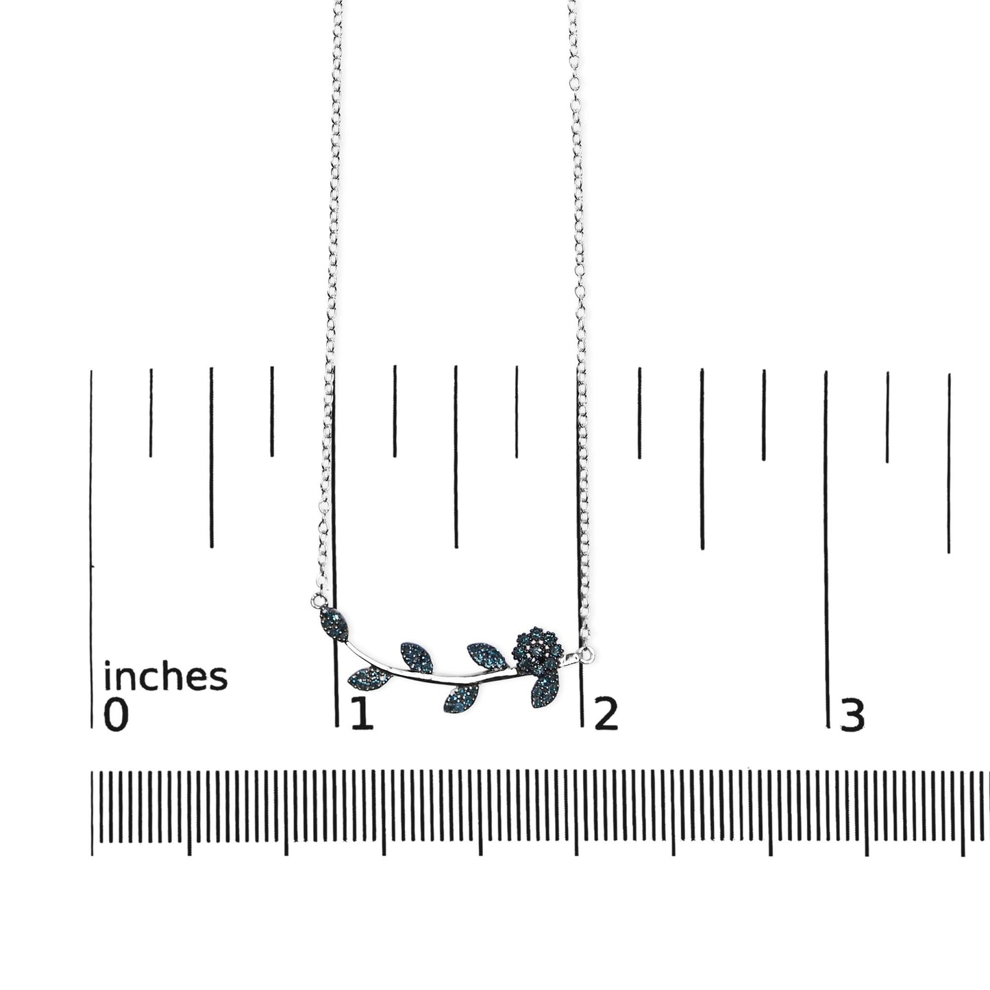 White metal necklace with a floral and leaf design set with blue round gemstones, shown flat on a ruler for size reference, front-facing angle.