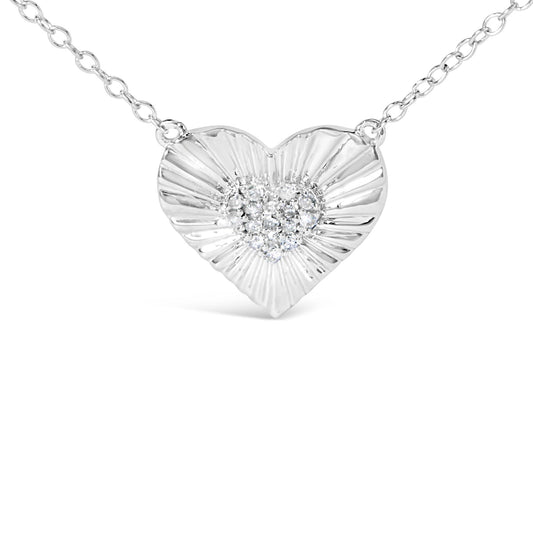 Close-up front view of a white metal heart-shaped necklace pendant with a cluster of round white gemstones in the center, on a white metal chain.
