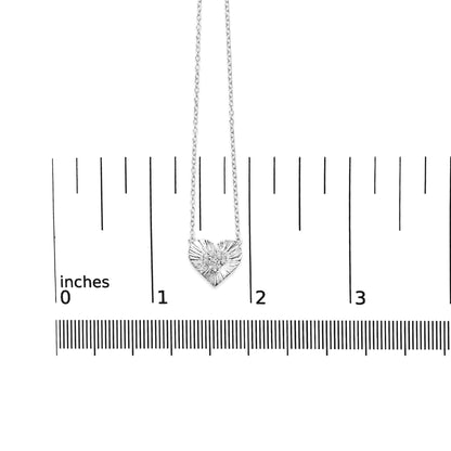 White metal heart-shaped necklace with round white gemstones in prong setting, displayed flat on a ruler for size reference, front-facing angle.
