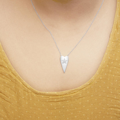 Close-up front view of a model wearing a white necklace with a pointed pendant featuring a star shape set with small white gemstones.