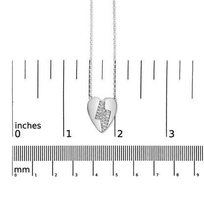 Front-facing shot of a white metal heart-shaped necklace pendant with a lightning bolt design set with white round prong-set gemstones, displayed on a ruler for size reference.