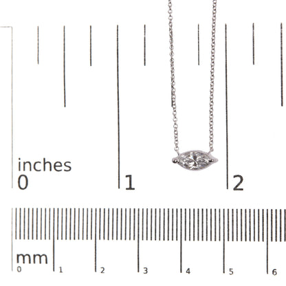 Close-up front view of white metal necklace with a marquise-shaped white gemstone in a 2-prong setting, placed on a ruler for size reference.