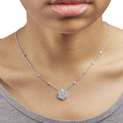 Close-up front view of a white necklace with round prong-set white gemstones, worn on a model.