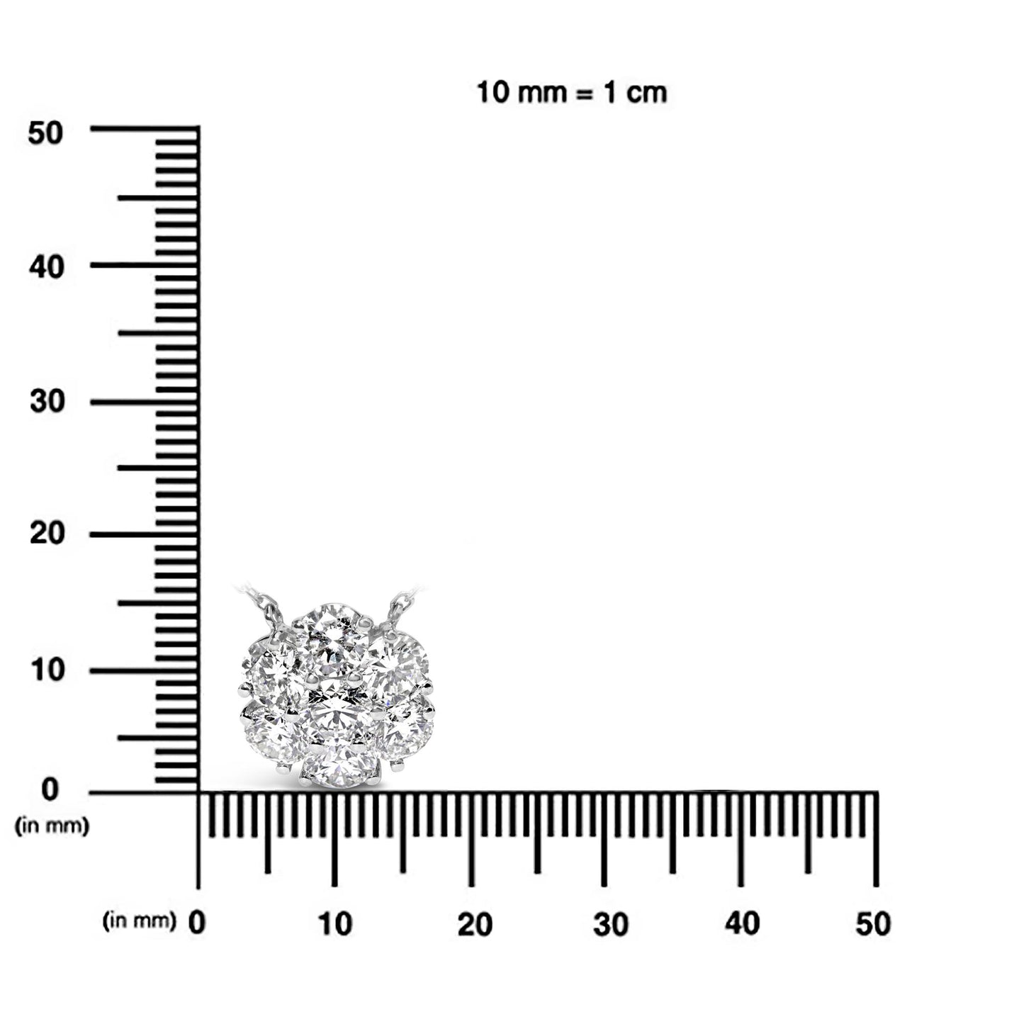 Close-up front view of a white necklace pendant with round white gemstones in prong settings, placed on a ruler for size reference.