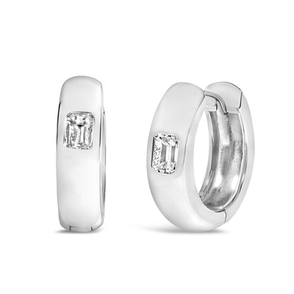 Close-up front angle of a pair of white metal hoop earrings, each featuring a bezel-set white emerald-shaped gemstone.