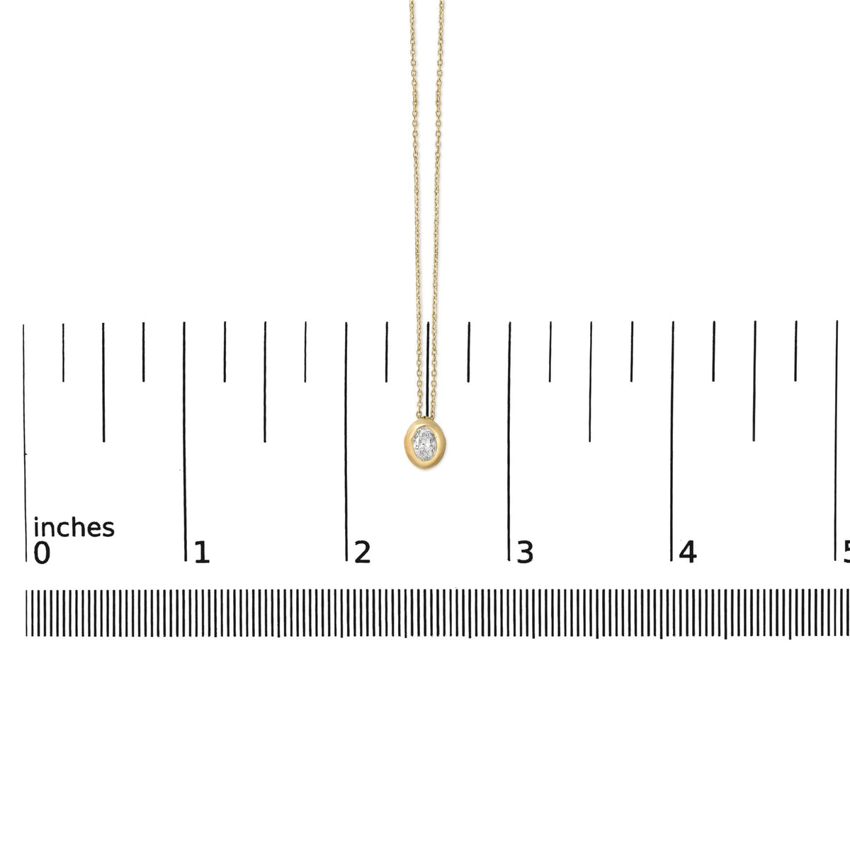 Yellow necklace with an oval white gemstone in bezel setting shown on a scale from a front angle.