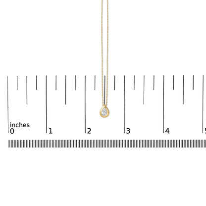 Close-up front view of a yellow necklace with a pear-shaped white gemstone in a bezel setting, shown on a ruler scale.