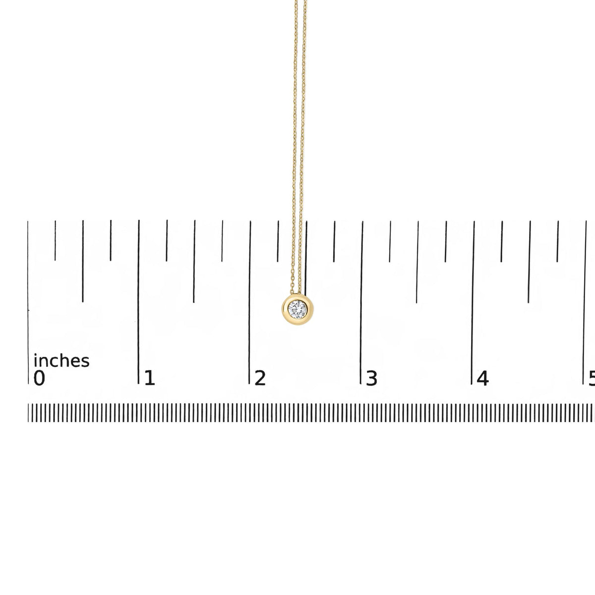 Close-up front view of a yellow necklace with a round white gemstone in a bezel setting, shown on a scale.