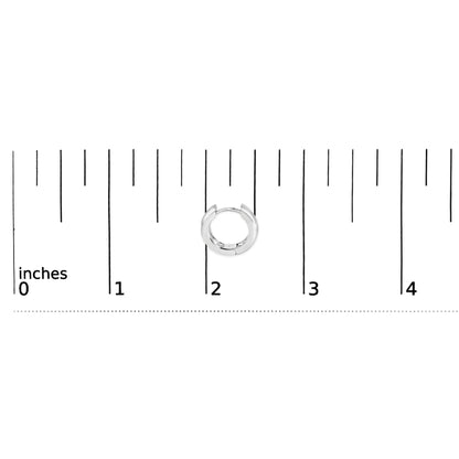 Front view of 14K white gold pear diamond bezel set huggie earrings against an inch measurement scale