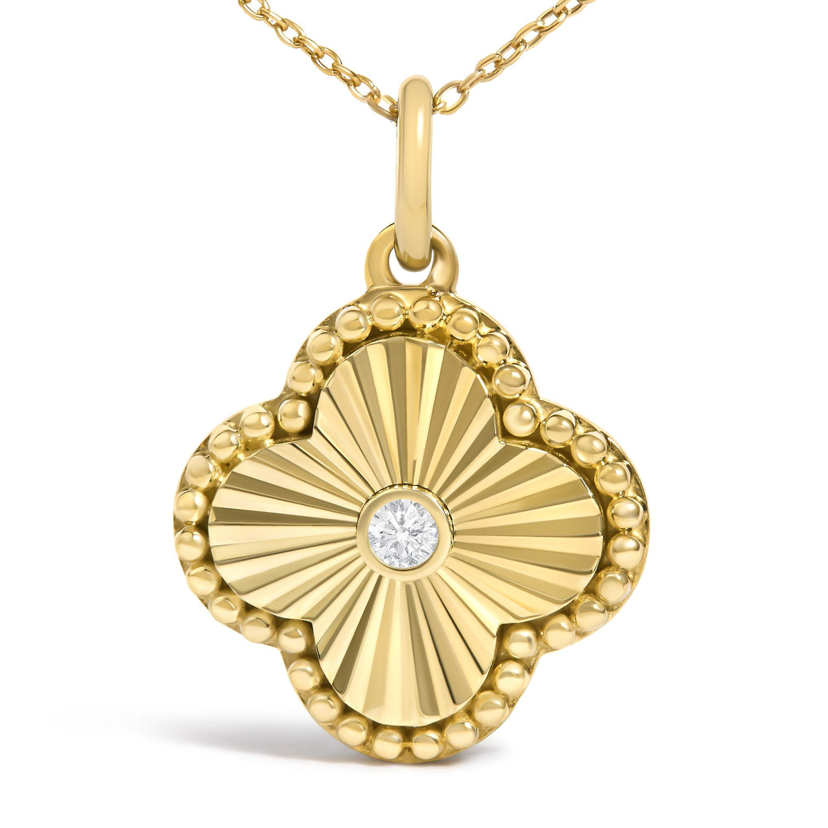 Close-up front view of a yellow metal necklace pendant with a faceted radiating design and beaded edge, featuring a single round white gemstone in a bezel setting at the center.