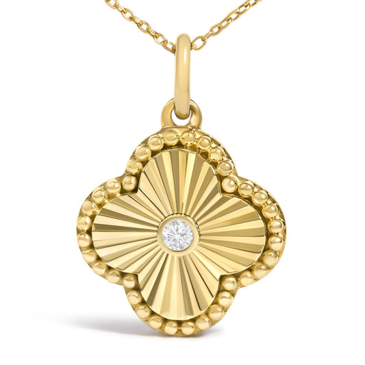 Close-up front view of a yellow metal necklace pendant with a faceted radiating design and beaded edge, featuring a single round white gemstone in a bezel setting at the center.