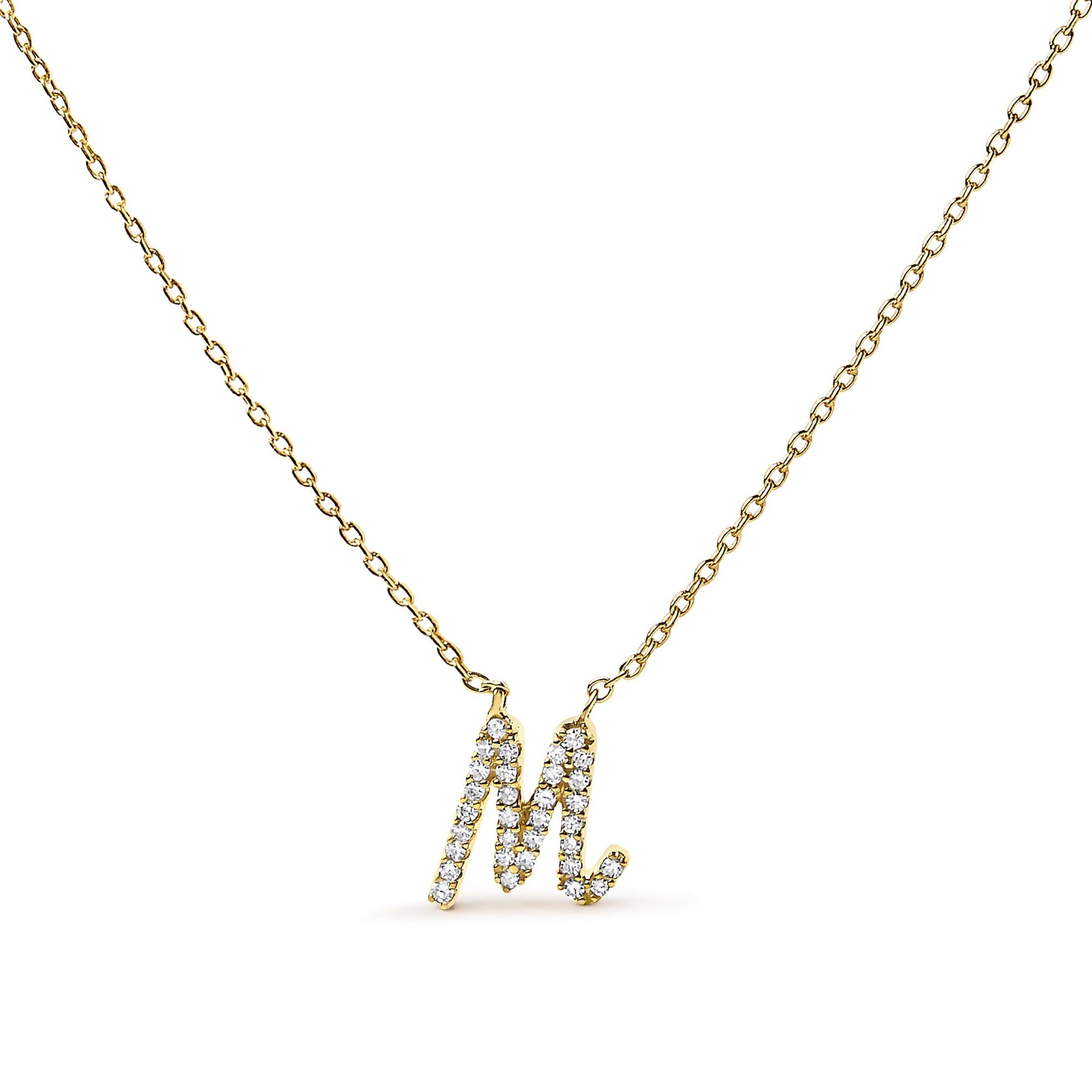 Front-facing shot of a yellow metal necklace with a pendant in the shape of the letter M, adorned with small white gemstones in a micro-pave setting.