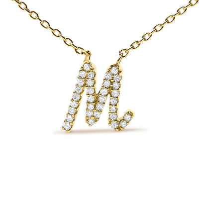 Close-up front angle of a yellow metal necklace with a pendant shaped like the letter M, encrusted with round white gemstones in a micro-pave setting.
