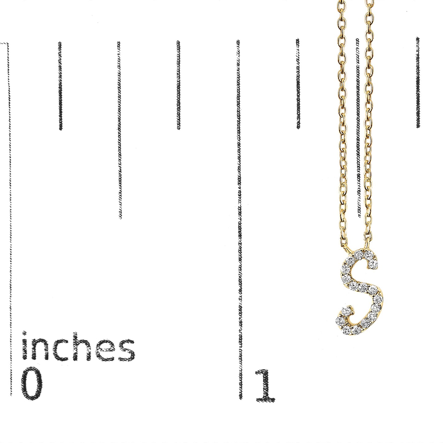 Close-up front view of a yellow metal necklace with a pendant in the shape of the letter 'S' adorned with small white gemstones, shown hanging on a scale marked in inches.