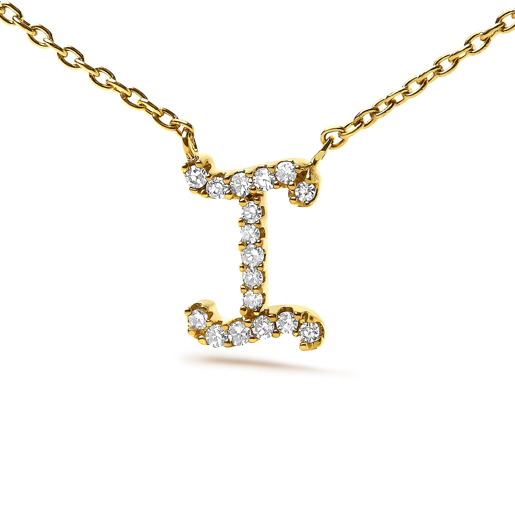 Close-up front view of a yellow metal necklace with a pendant shaped like the letter 'I' adorned with round white gemstones in a micro-pave setting.