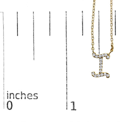Close-up front view of a yellow necklace pendant shaped like the letter 'I' with white round gemstones in a micro-pave setting, shown on a scale.