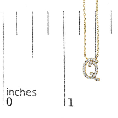 Close-up front view of a yellow necklace pendant shaped like the letter Q adorned with round white gemstones in a micro-pave setting, shown on a scale.