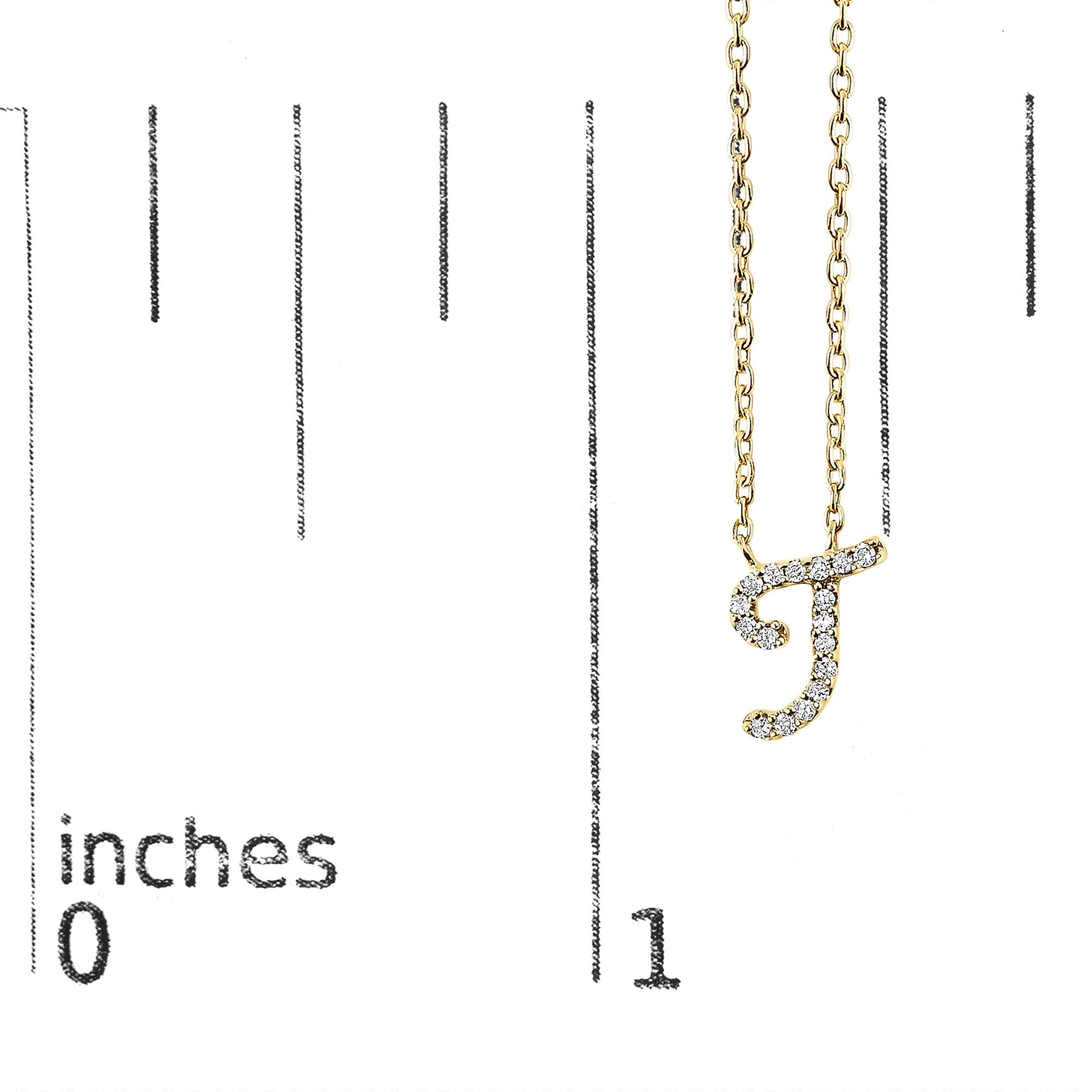 Yellow metal necklace with a pendant in the shape of the letter 'J' adorned with round white gemstones in a micro-pave setting, shown hanging on a scale with inch measurements, front view.