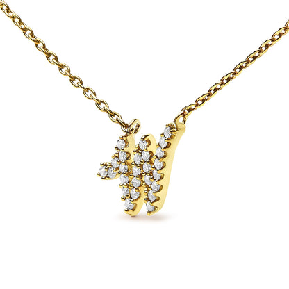 Close-up front angle of a yellow metal necklace with a pendant shaped like the letter 'W,' set with multiple small round white gemstones in a micro-pave setting.