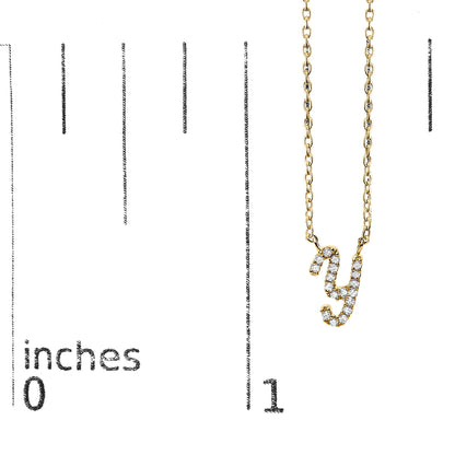 Close-up front view of a yellow necklace shown on a scale, featuring a pendant shaped like the letter 'y' adorned with white round gemstones in micro-pave setting.