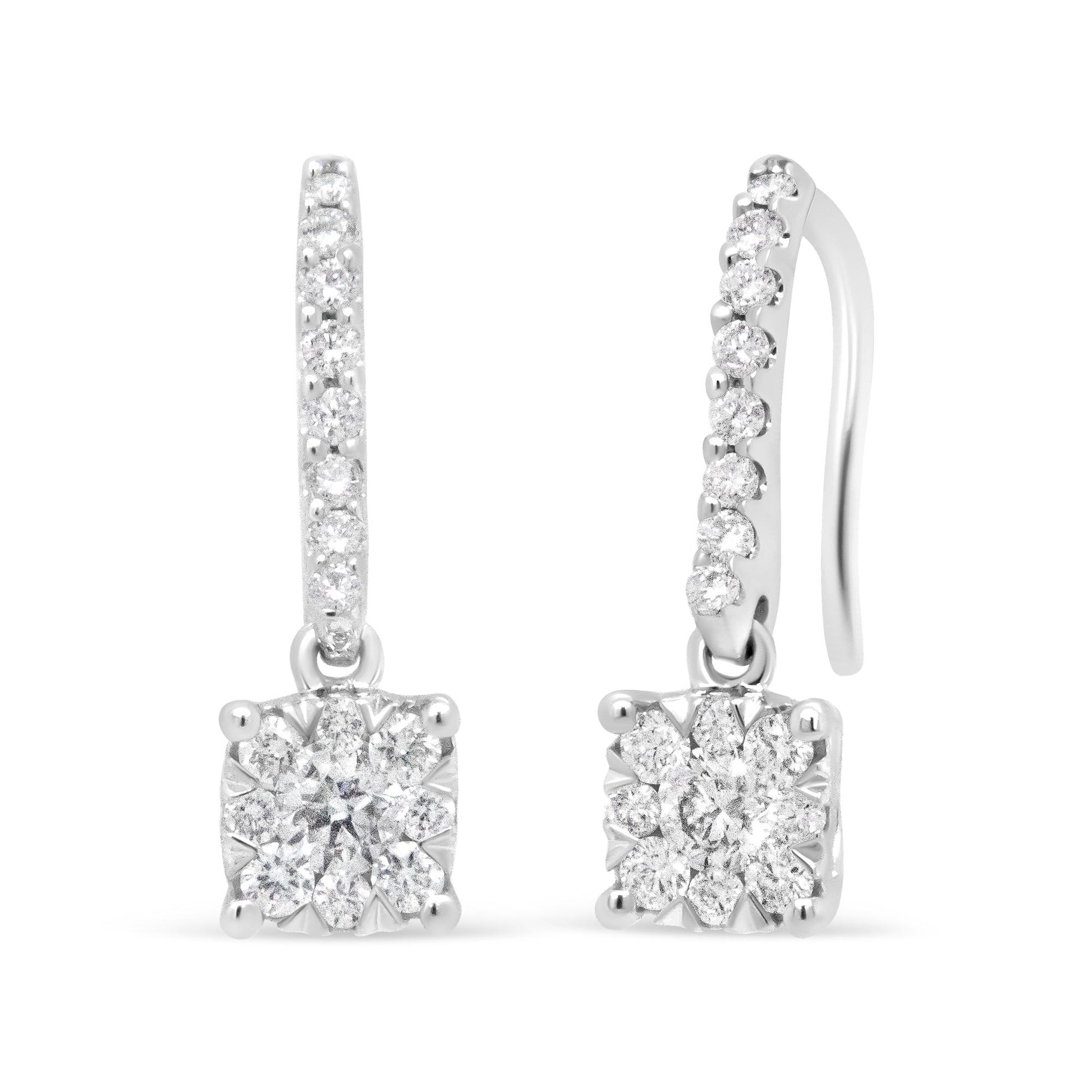 Front and side angled view of white metal drop earrings with white round gemstones in prong and pave settings.