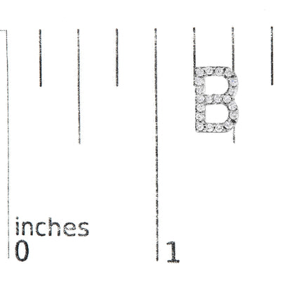 Close-up front view of a white metal earring shaped like the letter B, encrusted with round white gemstones in a micro-pave setting, shown on a measurement scale.