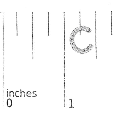 Close-up front angle of one white hoop earring with round white gemstones in micro-pave setting, shown on a scale marked in inches.