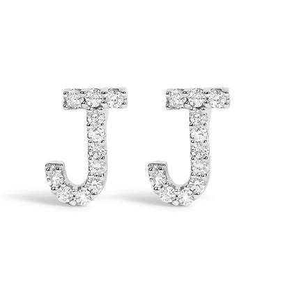 Front view of a pair of white metal earrings shaped like the letter J, each adorned with multiple small white gemstones in a micro-pave setting.