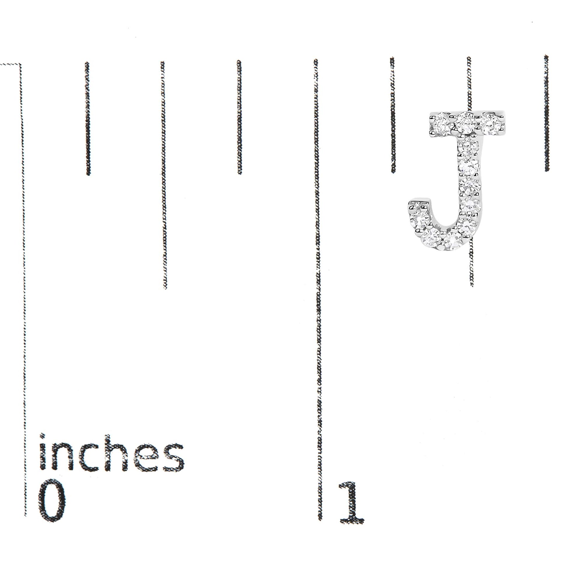 White metal earring shaped like the letter J with round white gemstones in a micro-pave setting, shown on a scale angled from above.