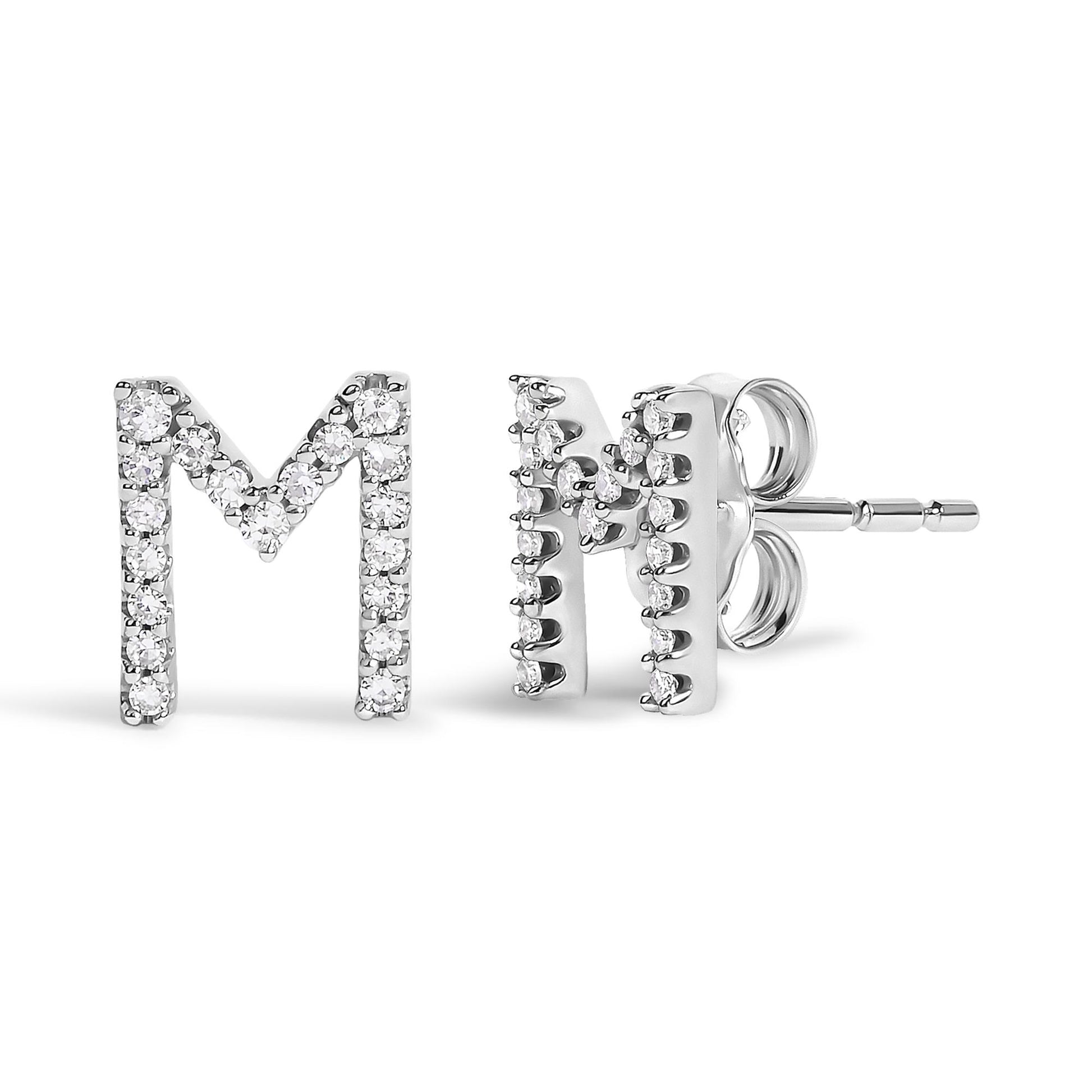 Pair of white metal stud earrings shaped like the letter M, adorned with round white gemstones in a micro-pave setting, shown from the front and side on a white background.