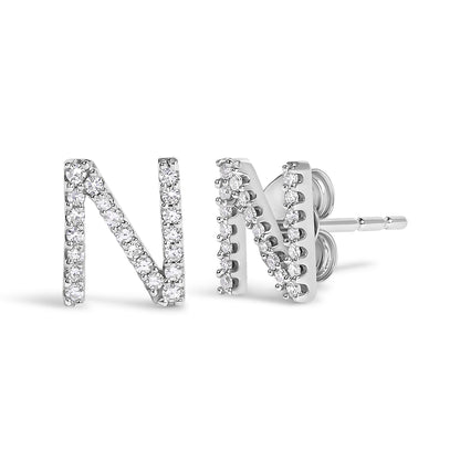 Close-up front and side view of a pair of white metal stud earrings shaped as the letter N, adorned with round white gemstones in a micro-pave setting.