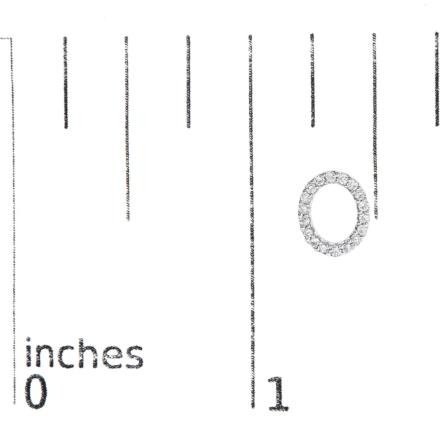 Close-up of a white circular earring with white round gemstones in a micro-pave setting, shown on a scale with inch markings.