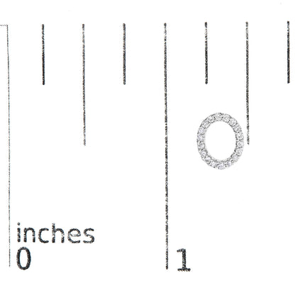 Close-up of a white circular earring with white round gemstones in a micro-pave setting, shown on a scale with inch markings.