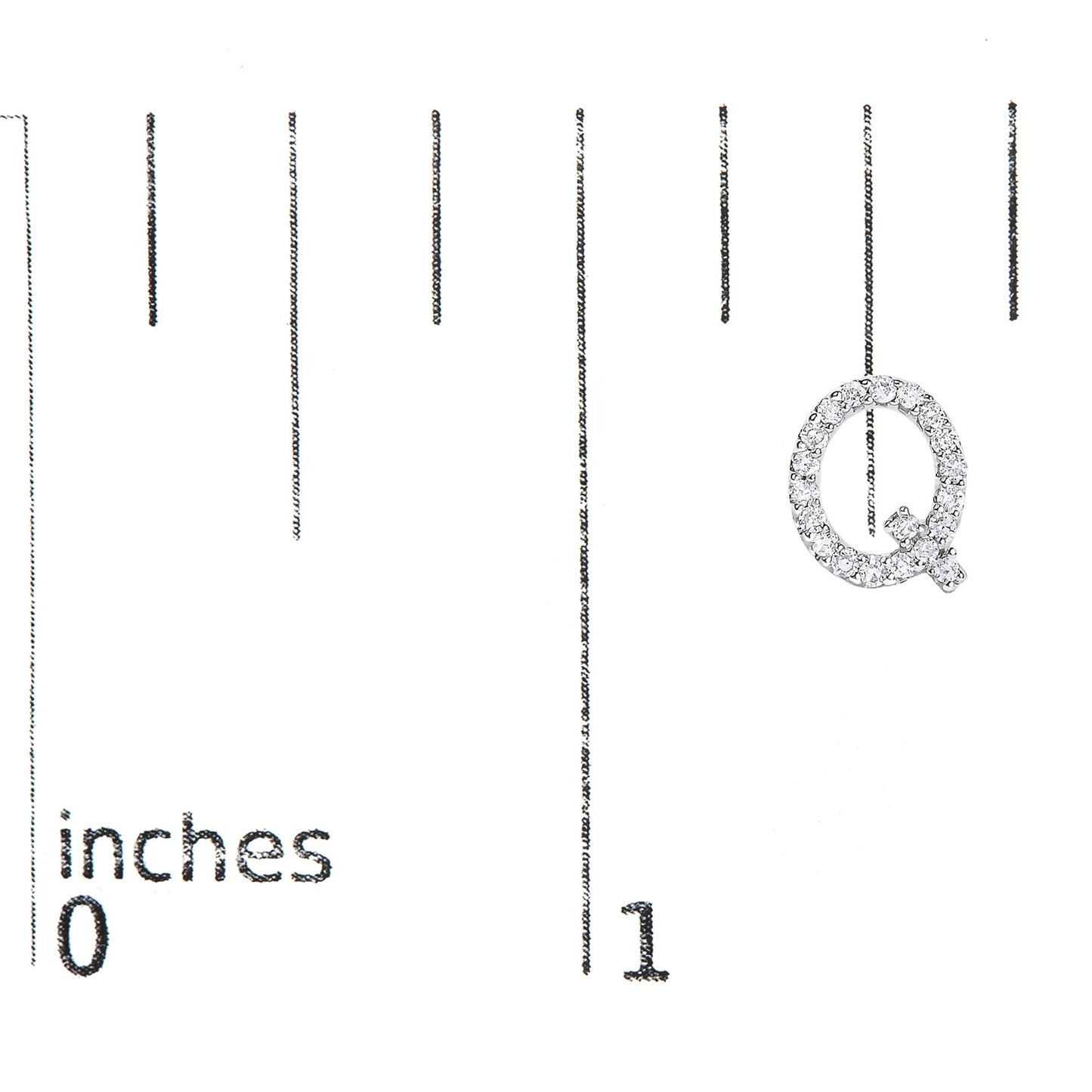 Close-up front view of a white metal earring shaped like the letter Q, adorned with small white gemstones in a micro-pave setting, shown on a scale marked in inches.