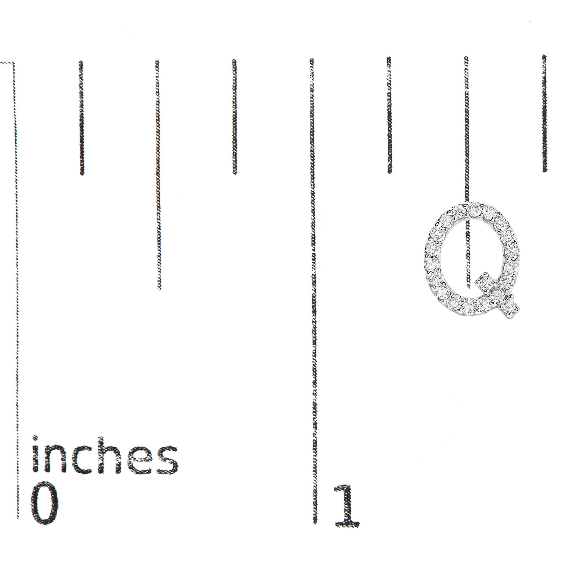 Close-up front view of a white metal earring shaped like the letter Q, adorned with small white gemstones in a micro-pave setting, shown on a scale marked in inches.