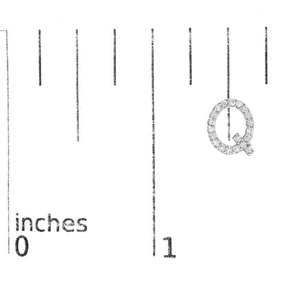 Close-up front view of a white metal earring shaped like the letter Q, adorned with small white gemstones in a micro-pave setting, shown on a scale marked in inches.