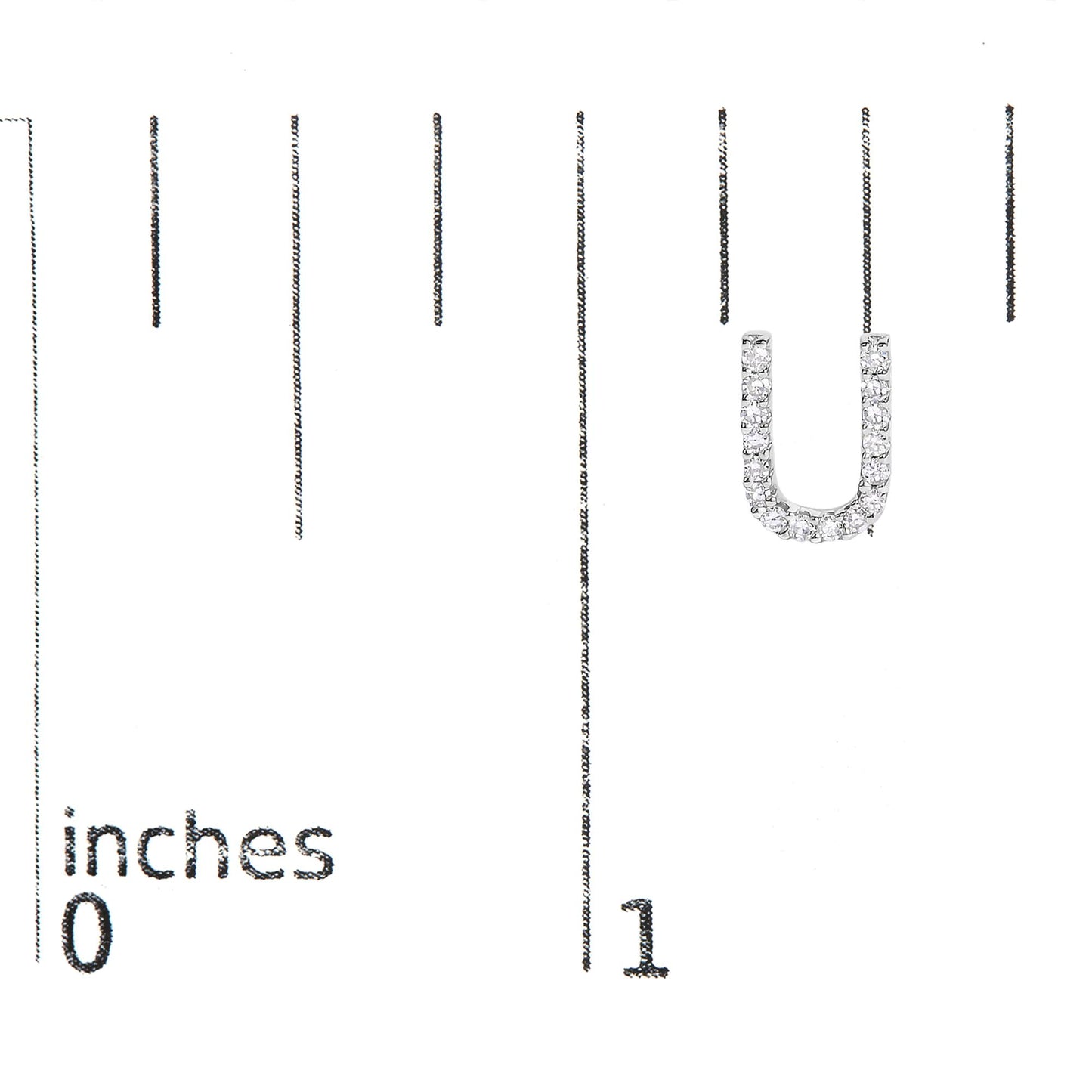 Close-up of a single white metal earring in a U-shape, adorned with round white gemstones in micro-pave setting, shown on a measurement scale.