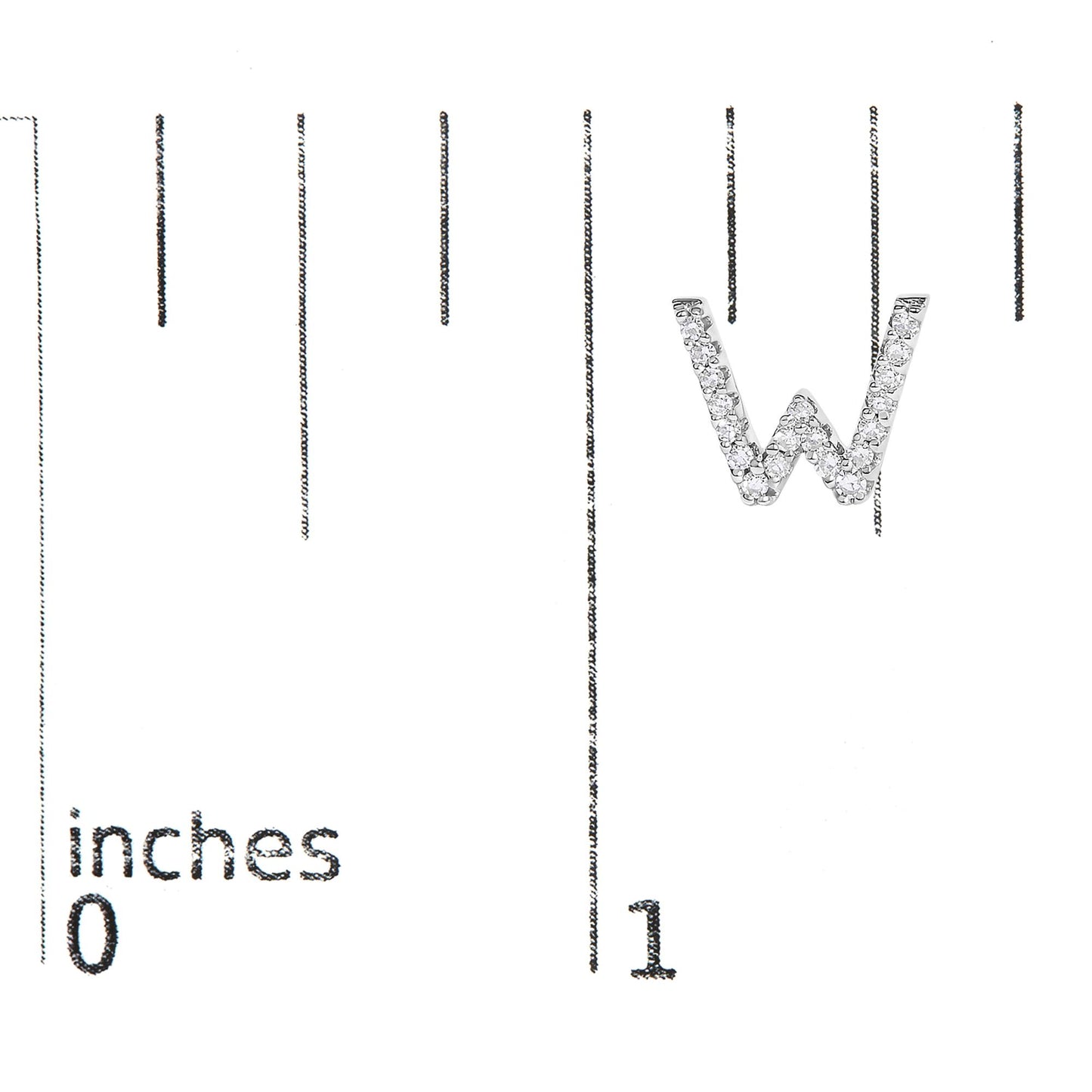 Close-up of a white metal earring shaped as the letter W, adorned with round white gemstones in micro-pave setting, shown on a ruler for scale from a top angled view.